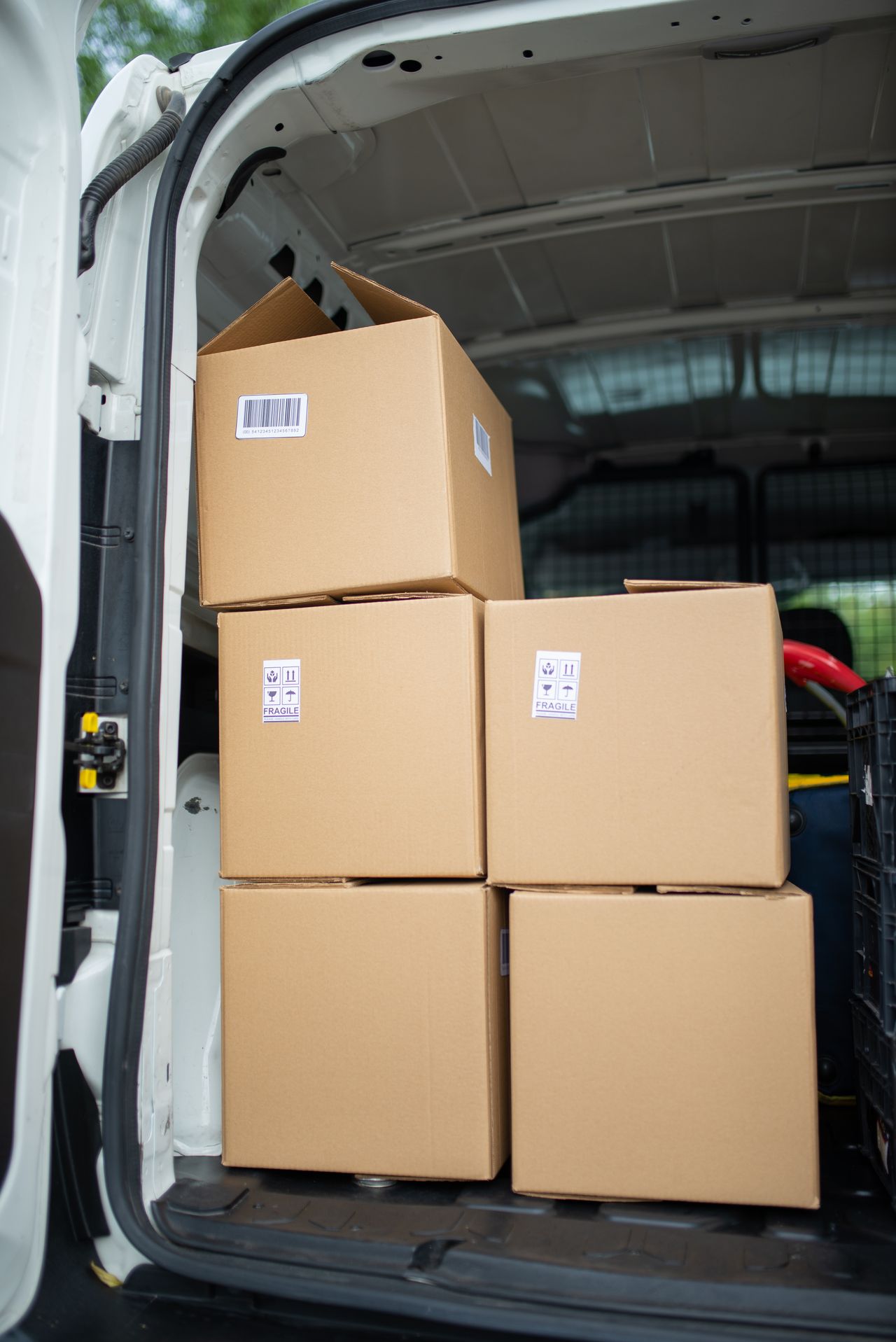 Cartons chargés à l'arrière d'un utilitaire, prêts pour une tournée